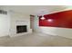 A cozy living room featuring a white brick fireplace and unique red accent wall at 712 Beaver Dam Rd, Raleigh, NC 27607