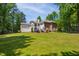 Expansive backyard with lush green grass, mature trees and a large home at 7309 New Forest Ln, Wake Forest, NC 27587