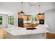 Bright kitchen with a marble countertop island, wood cabinets, stainless steel appliances, and modern light fixtures at 7309 New Forest Ln, Wake Forest, NC 27587