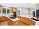 Updated kitchen featuring wood cabinets, marble countertops, stainless appliances, and an island cooktop at 7309 New Forest Ln, Wake Forest, NC 27587