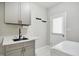 Well-lit laundry room with modern gray cabinets, a sink, and a marble-style countertop at 7309 New Forest Ln, Wake Forest, NC 27587