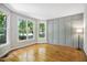 Living room with hardwood floors, three large windows, and gray paneled accent wall at 7309 New Forest Ln, Wake Forest, NC 27587