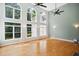 Bright living room with hardwood floors, ceiling fan, and large windows overlooking the backyard at 7309 New Forest Ln, Wake Forest, NC 27587