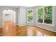 Living room with hardwood floors, three large windows, archway, and white trim at 7309 New Forest Ln, Wake Forest, NC 27587