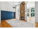 Open-concept living room with fireplace, wood floors, blue accent wall, and ample natural light at 7309 New Forest Ln, Wake Forest, NC 27587