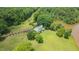 Stunning aerial view of a well-maintained home surrounded by lush greenery and a private pond at 771 Cedar Grove Church Rd, Roxboro, NC 27574