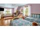 Spacious bedroom with hardwood floors, two beds, and sitting area perfect for relaxing or play at 771 Cedar Grove Church Rd, Roxboro, NC 27574