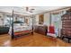 View of bedroom with hardwood floors, 4-poster bed, sitting area and custom decor at 771 Cedar Grove Church Rd, Roxboro, NC 27574