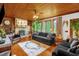 Comfortable living room with wood ceilings, hardwood floors, large windows, stone fireplace and nice decor at 771 Cedar Grove Church Rd, Roxboro, NC 27574