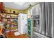 View of walk-in pantry with storage shelves, canned goods, and stainless steel refrigerator at 771 Cedar Grove Church Rd, Roxboro, NC 27574