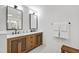 Bathroom featuring a double vanity with wood cabinets, black faucets and a tiled floor at 7816 Harbor Dr, Raleigh, NC 27615