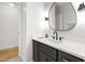 Bathroom featuring a stylish vanity with black hardware, modern lighting, and wood floors at 7816 Harbor Dr, Raleigh, NC 27615