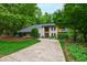 Stylish two-story home surrounded by lush greenery, with stone and wood accents and curved driveway at 7816 Harbor Dr, Raleigh, NC 27615