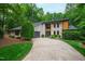 Stylish two-story home featuring stone and wood accents, lush landscaping and a curved driveway at 7816 Harbor Dr, Raleigh, NC 27615