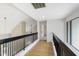Upstairs hallway boasts hardwood floors, black railings, and natural light at 7816 Harbor Dr, Raleigh, NC 27615