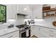 Kitchen featuring stainless steel appliances, gas cooktop, marble countertops, and white cabinetry at 7816 Harbor Dr, Raleigh, NC 27615