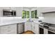 Bright kitchen with white cabinets, stainless steel appliances and marble countertops near garden window at 7816 Harbor Dr, Raleigh, NC 27615
