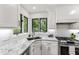 Bright kitchen featuring stainless steel appliances, marble countertops, white cabinetry and a large window at 7816 Harbor Dr, Raleigh, NC 27615
