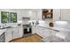 Bright kitchen with white cabinets, stainless steel appliances and marble countertops at 7816 Harbor Dr, Raleigh, NC 27615