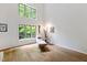 Airy living room featuring large windows, hardwood floors, lounge chair, and ample natural light at 7816 Harbor Dr, Raleigh, NC 27615