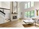 Bright living room with fireplace, hardwood floors, staircase, and large windows offering scenic outdoor views at 7816 Harbor Dr, Raleigh, NC 27615