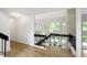 Open staircase with black railing overlooking the living room with tall ceilings and large windows at 7816 Harbor Dr, Raleigh, NC 27615
