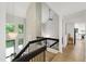 Open staircase with black railing overlooking the living room featuring a white brick fireplace at 7816 Harbor Dr, Raleigh, NC 27615