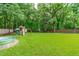 Green backyard featuring a playground and a stock tank pool at 8505 Stonegate Dr, Raleigh, NC 27615