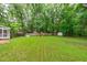 Lush backyard with mature trees, play equipment, pool, and storage shed at 8505 Stonegate Dr, Raleigh, NC 27615