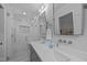 Modern bathroom featuring double sinks and a walk-in shower with a glass door at 8505 Stonegate Dr, Raleigh, NC 27615