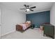 Comfortable bedroom featuring a ceiling fan and an accent wall at 8505 Stonegate Dr, Raleigh, NC 27615