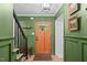Welcoming foyer with a stylish front door, rich green walls, and staircase at 8505 Stonegate Dr, Raleigh, NC 27615