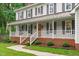 Inviting front porch with white railings, brick accents, and a warm, welcoming entrance at 8505 Stonegate Dr, Raleigh, NC 27615
