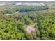An aerial view showcases the property nestled in a wooded area with a pond and nearby parking at 8816 Valley Springs Pl, Raleigh, NC 27615