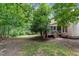 The backyard features mature trees and access to a screened porch and deck at 8816 Valley Springs Pl, Raleigh, NC 27615