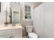 Clean bathroom features a white vanity, toilet, shower with curtain, and a window for natural light at 8816 Valley Springs Pl, Raleigh, NC 27615