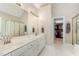 Primary bathroom with dual sinks, walk in closet, shower with glass door and tile floors at 8816 Valley Springs Pl, Raleigh, NC 27615