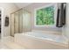 Bright bathroom features a garden tub with jets and a glass-enclosed shower at 8816 Valley Springs Pl, Raleigh, NC 27615