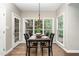 Well-lit dining room features hardwood floors, a view of the trees, and a dining table with chairs at 8816 Valley Springs Pl, Raleigh, NC 27615