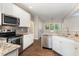 Beautiful kitchen with stainless steel appliances, granite countertops, hardwood floors, and white cabinets at 8816 Valley Springs Pl, Raleigh, NC 27615