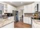 Well-lit kitchen featuring white cabinets, stainless steel appliances, granite countertops, and hardwood floors at 8816 Valley Springs Pl, Raleigh, NC 27615