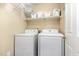 Functional laundry room includes washer, dryer, storage shelves and baskets for organizing household essentials at 8816 Valley Springs Pl, Raleigh, NC 27615