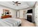 Large main bedroom features carpet, ceiling fan, fireplace, tv, and an attached bathroom at 8816 Valley Springs Pl, Raleigh, NC 27615