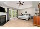 Spacious main bedroom features carpet, ceiling fan, fireplace, doors to outside, and lots of natural light at 8816 Valley Springs Pl, Raleigh, NC 27615