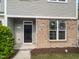 Inviting townhouse entrance with a black front door and brick detailing, showcasing curb appeal at 8891 Commons Townes Dr, Raleigh, NC 27616