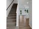 Interior view showcasing the staircase and modern kitchen with stainless appliances and granite counters at 8891 Commons Townes Dr, Raleigh, NC 27616