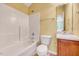 Bright bathroom featuring a tub with white tile surround, vanity, and neutral wall paint at 921 Shefford Town Dr, Rolesville, NC 27571