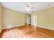 Bedroom with wood floors, ceiling fan, and two access doors to other rooms at 921 Shefford Town Dr, Rolesville, NC 27571