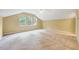 Spacious bonus room featuring a vaulted ceiling, three windows, and neutral carpet at 921 Shefford Town Dr, Rolesville, NC 27571