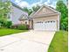 Two car garage featuring a large driveway and manicured lawn at 921 Shefford Town Dr, Rolesville, NC 27571